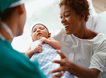 Doctor handing baby to patient