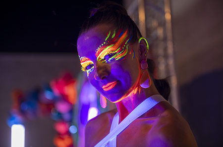 performer with glowing face paint