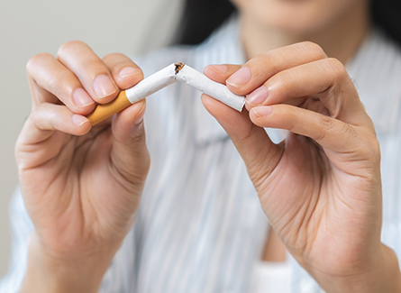 Woman snapping cigarette in half