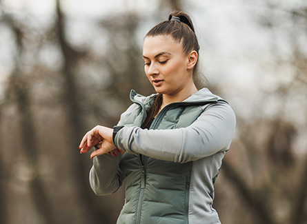 Woman checking her smartwatch while out for a run